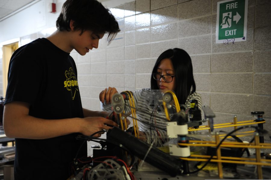 The captain of the Sciborgs, Lauren Siu '20 teaches the future captain, Xano Sweeting '21, how to work on a specific mechanism on the robot.