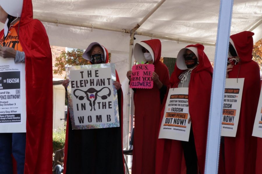 Demonstrators in Cleveland, Ohio, dress as Handmaids from Margret Atwood’s dystopian novel 'The Handmaid’s Tale.' The clothing from the novel became a symbol of the opposition to Justice Barrett after it was claimed that the patriarchal society of the novel was based on the Catholic organization People of Praise, to which Barrett belonged. This claim has since been repudiated, but the symbolism has remained.