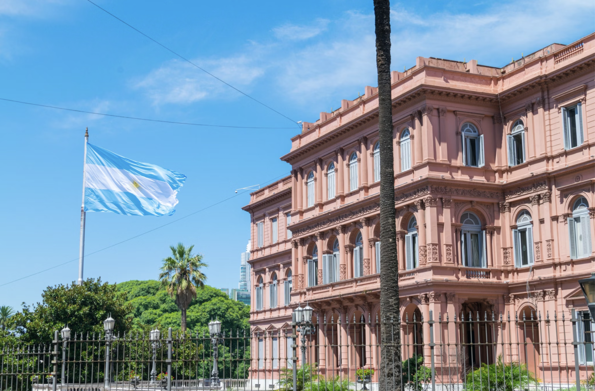 Here, the Argentine flag soars at Casa Rosada as citizens of the nation contemplate President Milei's economic reforms. (Photo Credit: Benjamin R. / Unsplash)