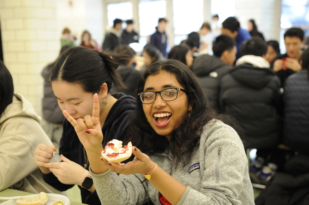 Ayshi Sen '24 at Senior Brunch enjoys a cream cheese and jelly bagel.