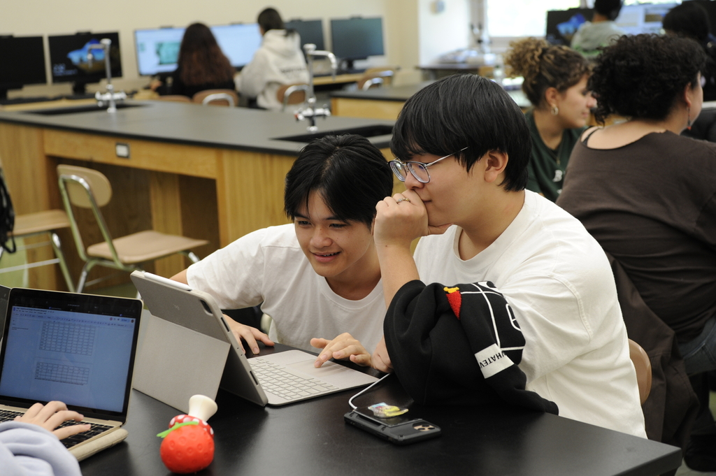 The photo above displays two students in their Animal Behavior class working on an ipad. One student charges their phone to the side.